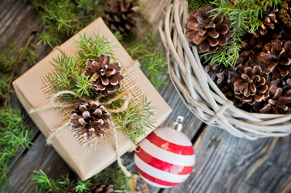 gift decorated with pine cones on the wooden background