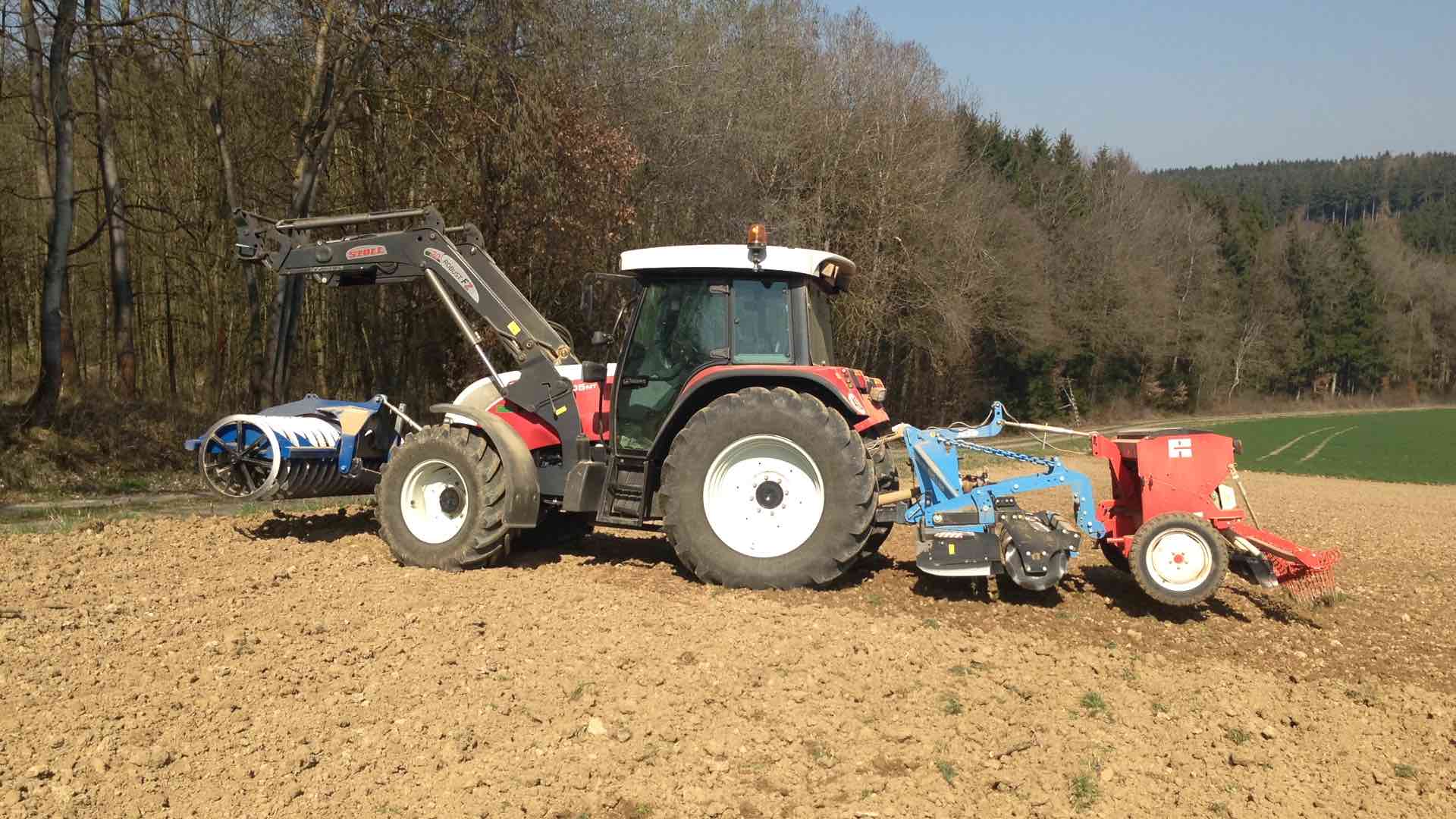 Traktor mit Sähmaschine auf dem Feld